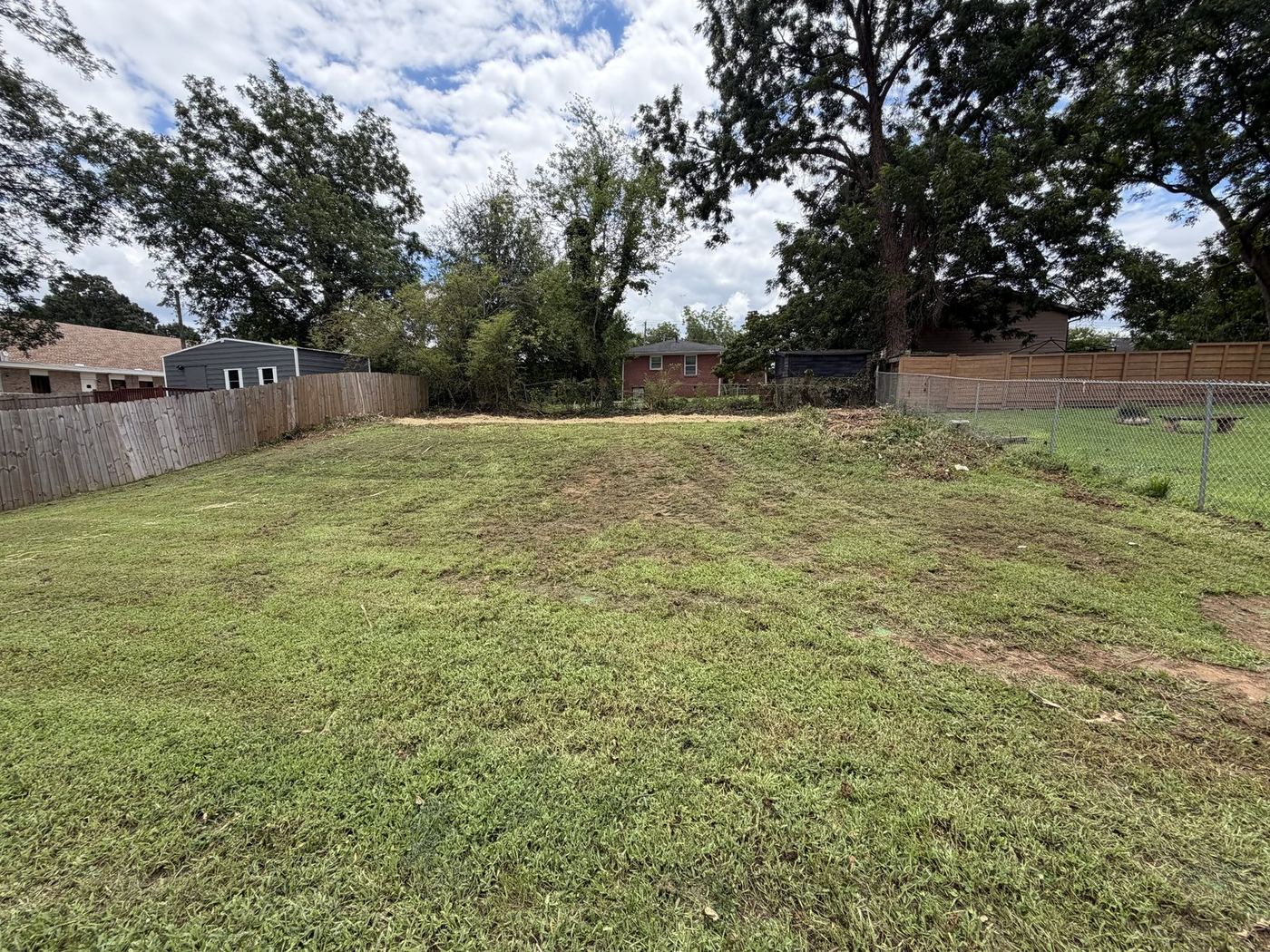 Backyard cleared and mowed to open usable ground, fence line exposed